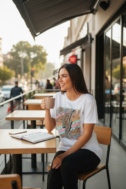 Restless white cotton t-shirt with "Stay Wild Bright" graphic featuring a lightning bolt, animal print, and pastel stripes.