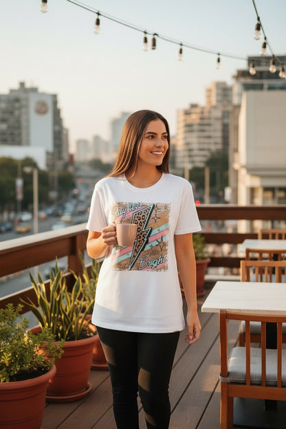 Restless white cotton t-shirt with a bold graphic featuring a lightning bolt with leopard print and pastel stripes, reading "Stay Wild Bright".